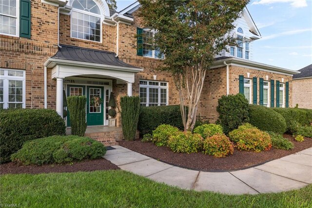 8602 Yvonne Ct, Oak Ridge, NC 27310 - entrance to property with a standing seam roof and brick siding