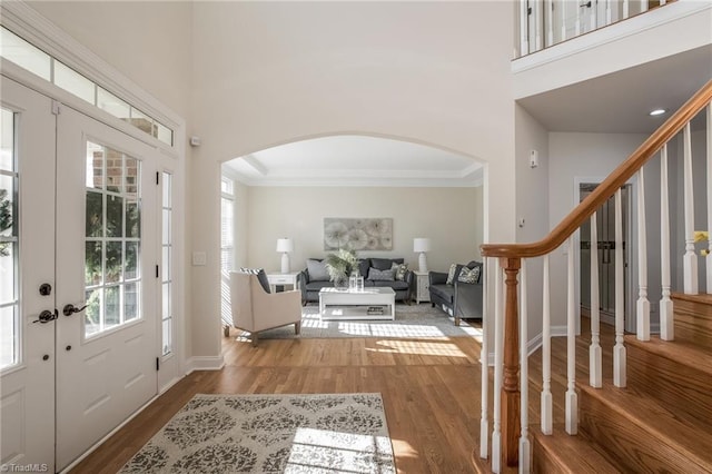 8602 Yvonne Ct, Oak Ridge, NC 27310 - foyer with baseboards, crown molding, a towering ceiling, wood finished floors, and arched walkways