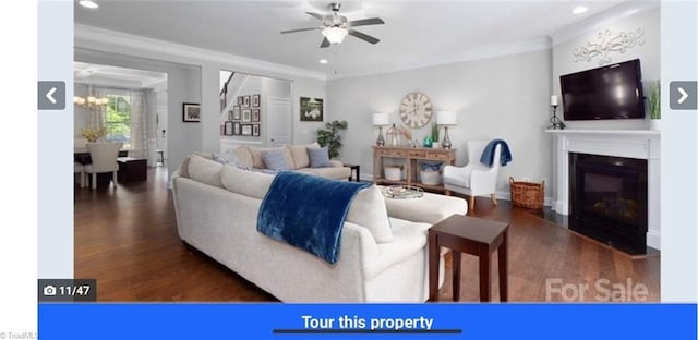 7464 Albemarle Ct, Denver, NC 28037 - living room featuring ceiling fan, crown molding, wood finished floors, a glass covered fireplace, and a chandelier