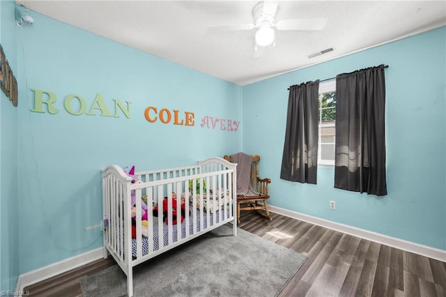 1705 Braemore Ct, Kernersville, NC 27284 - bedroom featuring visible vents, wood finished floors, baseboards, a crib, and a ceiling fan