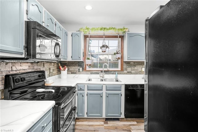 1705 Braemore Ct, Kernersville, NC 27284 - kitchen featuring light wood-style floors, a sink, backsplash, and black appliances
