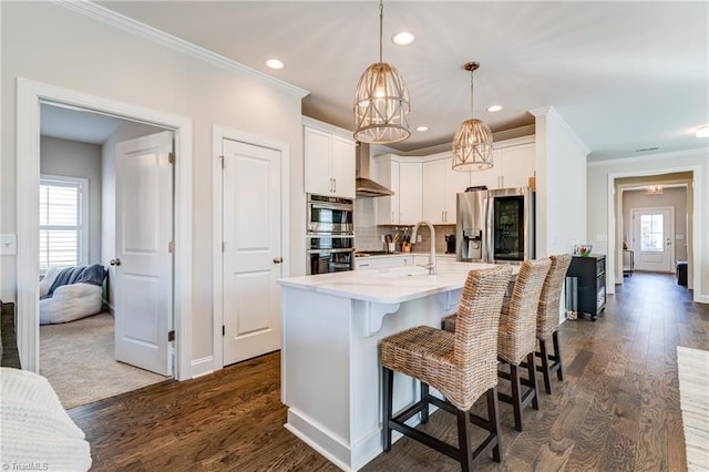 kitchen featuring hanging light fixtures, stainless steel appliances, a breakfast bar, and white cabinets