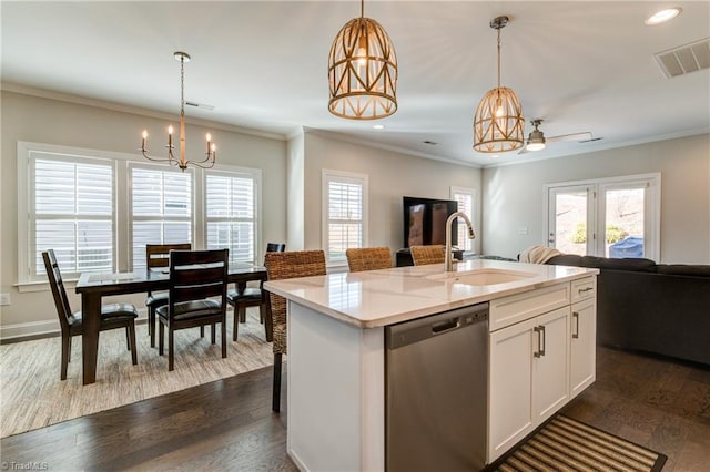 kitchen featuring a center island with sink, pendant lighting, and stainless steel dishwasher