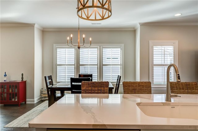 dining area with crown molding, an inviting chandelier, dark hardwood / wood-style floors, and sink