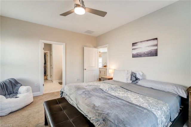 carpeted bedroom featuring ceiling fan and ensuite bath