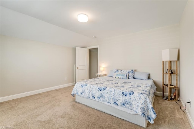 bedroom with vaulted ceiling and light colored carpet