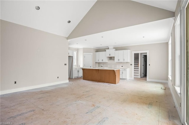 unfurnished living room featuring high vaulted ceiling