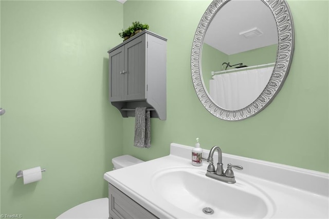 bathroom featuring a shower with shower curtain, vanity, and toilet