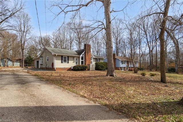 view of side of property with crawl space and a chimney