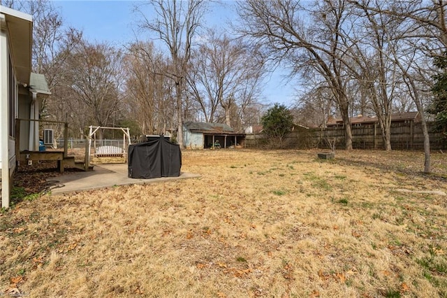 view of yard featuring a patio area, a storage unit, an outdoor structure, and a fenced backyard