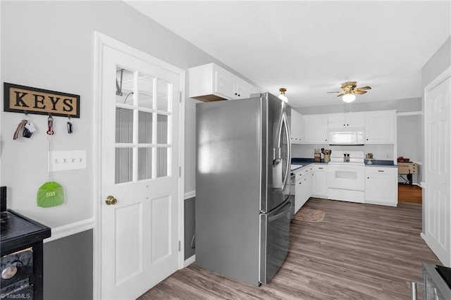 kitchen featuring white microwave, white cabinets, electric stove, stainless steel fridge with ice dispenser, and dark countertops