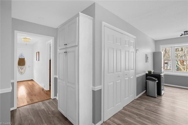 hallway with light wood-style flooring and baseboards