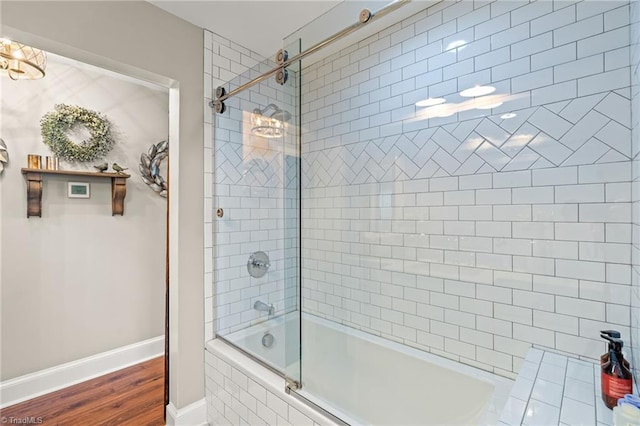 bathroom featuring hardwood / wood-style floors and shower / bath combination with glass door