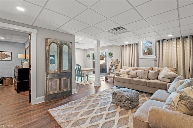 living room with a paneled ceiling and dark wood-type flooring