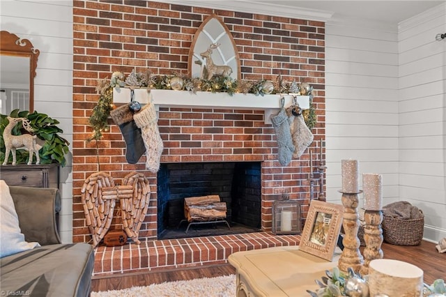 living room featuring hardwood / wood-style floors, a brick fireplace, and crown molding