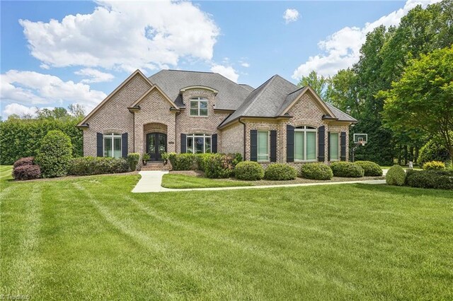 5200 Harley Stafford Dr, Oak Ridge, NC 27310 - view of front facade featuring brick siding, a front lawn, and french doors