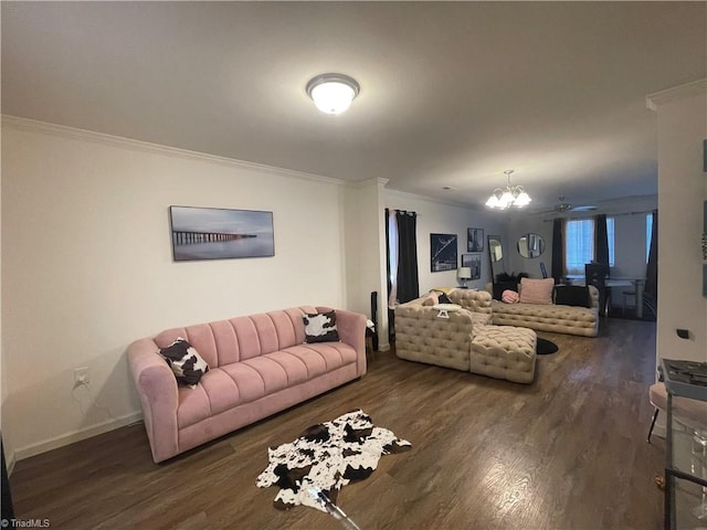 living room with dark wood-type flooring, ornamental molding, and a chandelier