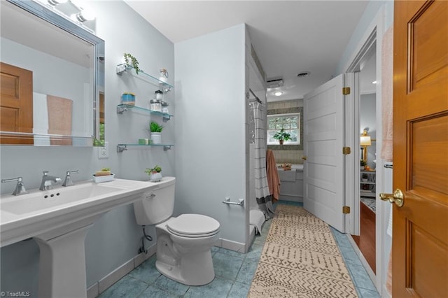 full bathroom featuring tile patterned floors, toilet, and curtained shower