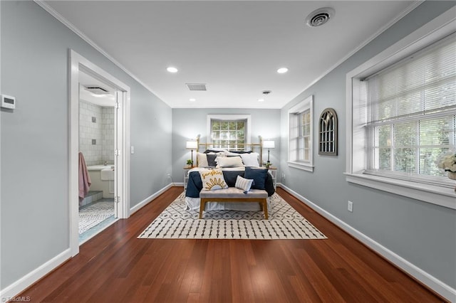 bedroom featuring visible vents, ornamental molding, and wood finished floors