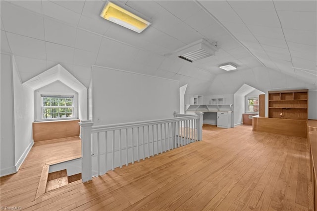 additional living space featuring wood-type flooring and vaulted ceiling
