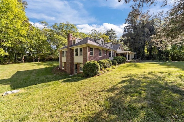 view of property exterior featuring a lawn, a chimney, and brick siding