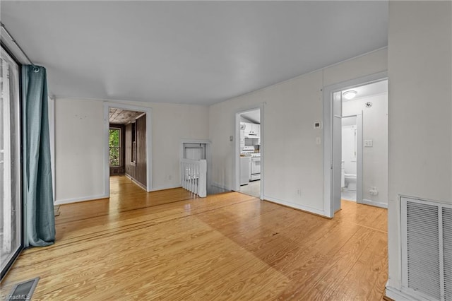 empty room with baseboards, visible vents, and wood finished floors