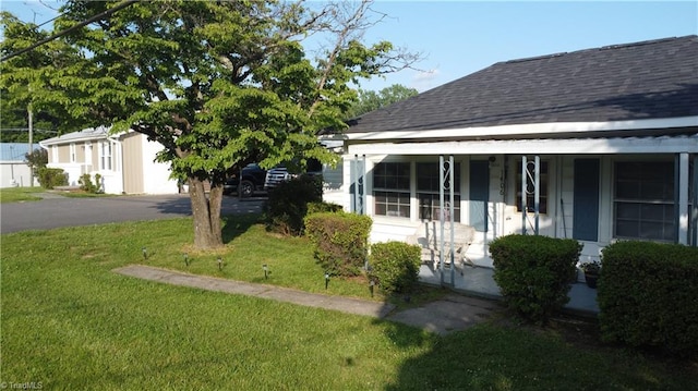 1406 E Pine St, Mount Airy, NC 27030 - view of home's exterior with a porch, a yard, roof with shingles, and asphalt driveway