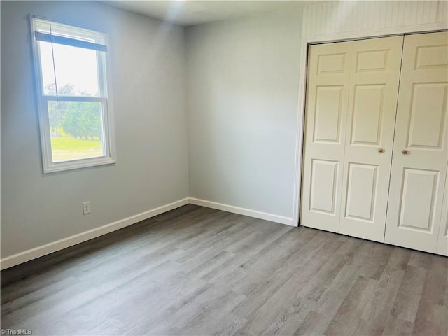 1406 E Pine St, Mount Airy, NC 27030 - unfurnished bedroom with wood finished floors, a closet, and baseboards