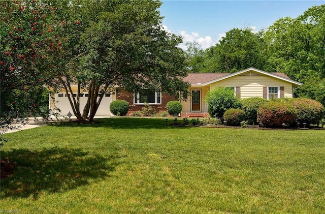 view of front of home with a front yard, a garage, brick siding, and driveway