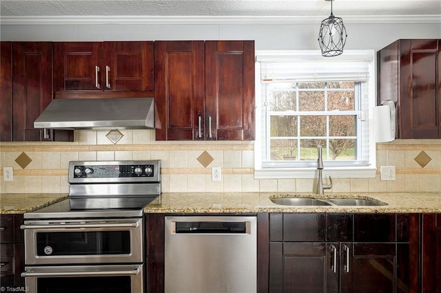 kitchen featuring appliances with stainless steel finishes, wall chimney range hood, a sink, reddish brown cabinets, and ornamental molding