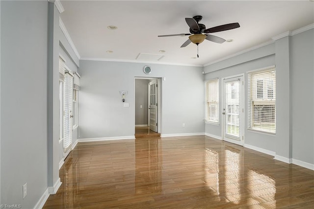 unfurnished room featuring ceiling fan, wood finished floors, baseboards, and crown molding