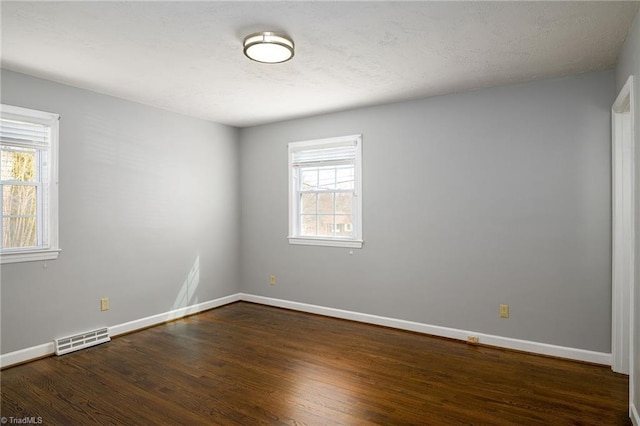 unfurnished room featuring dark wood-style flooring and baseboards