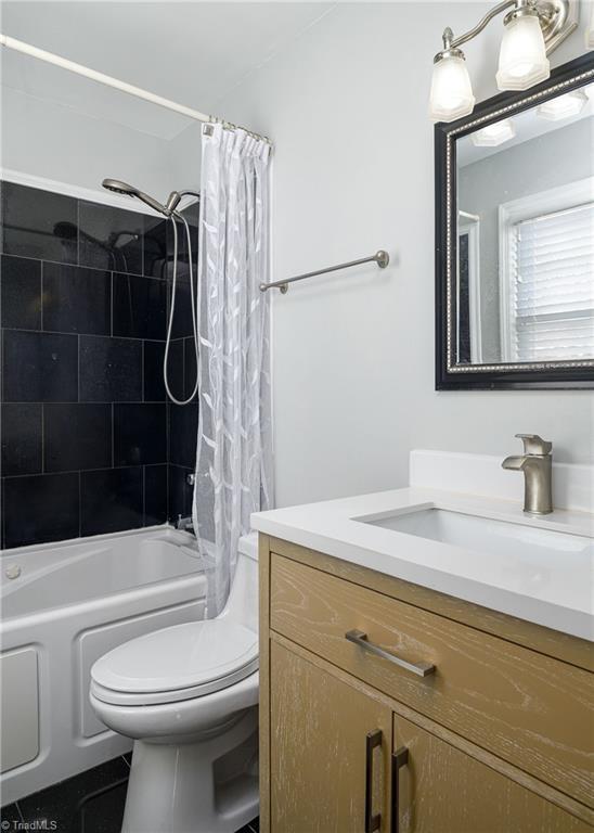 bathroom featuring shower / tub combo, vanity, and toilet