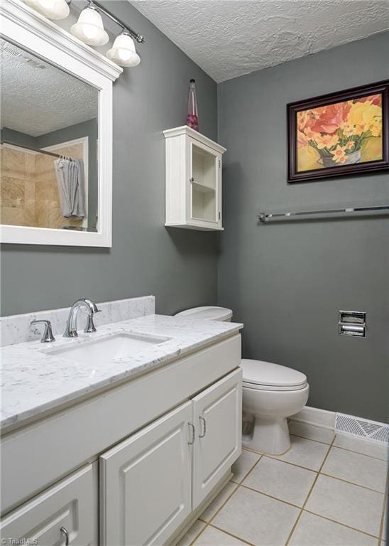 bathroom featuring a textured ceiling, tile patterned floors, toilet, vanity, and a shower with curtain