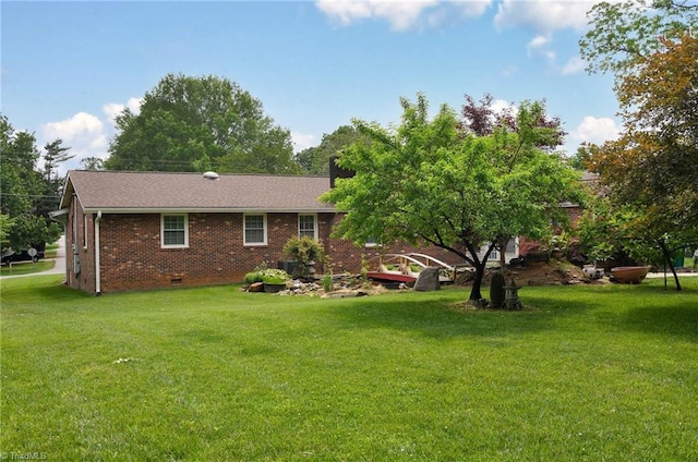 back of house with crawl space, a yard, and brick siding