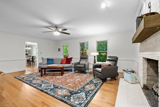 573 Doe Run Dr, Kernersville, NC 27284 - living area featuring wood finished floors, ceiling fan, a brick fireplace, crown molding, and baseboards