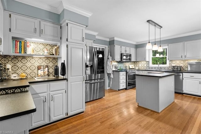 573 Doe Run Dr, Kernersville, NC 27284 - kitchen with stainless steel appliances, dark countertops, tasteful backsplash, light wood-style floors, and crown molding