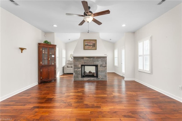 unfurnished living room featuring dark wood-style floors, visible vents, baseboards, and a stone fireplace