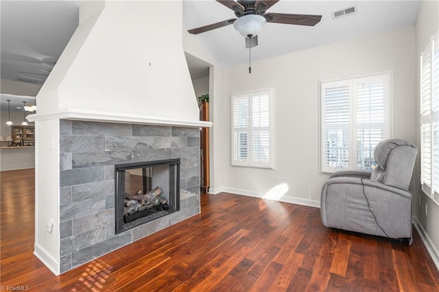 sitting room with wood finished floors, a ceiling fan, visible vents, baseboards, and a tiled fireplace