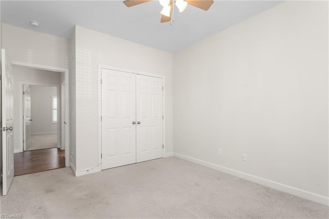 unfurnished bedroom featuring carpet, baseboards, and a closet