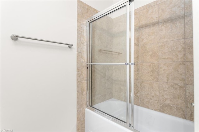 bathroom featuring bath / shower combo with glass door