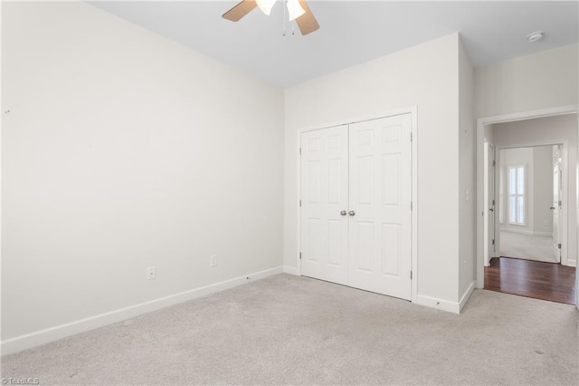 unfurnished bedroom featuring a ceiling fan, a closet, carpet flooring, and baseboards