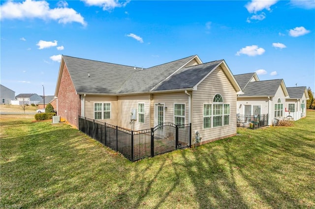 rear view of property featuring a yard, central AC unit, and fence