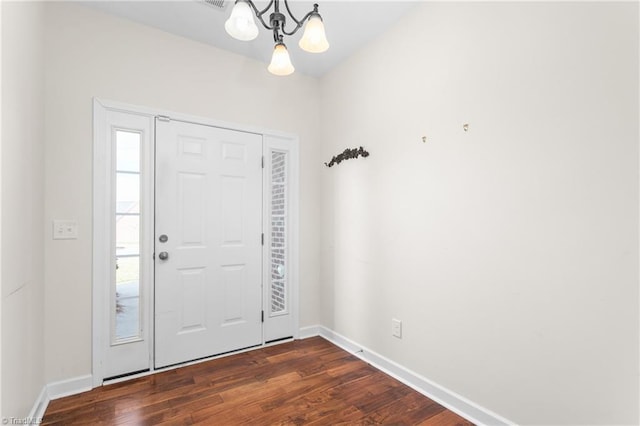 entryway featuring dark wood-style floors, baseboards, and an inviting chandelier