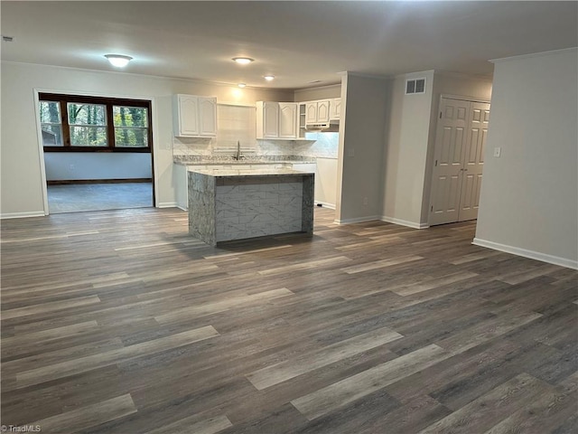 kitchen with white cabinetry, ornamental molding, dark hardwood / wood-style floors, and decorative backsplash