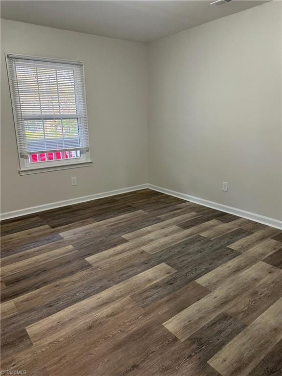 unfurnished room with dark hardwood / wood-style flooring