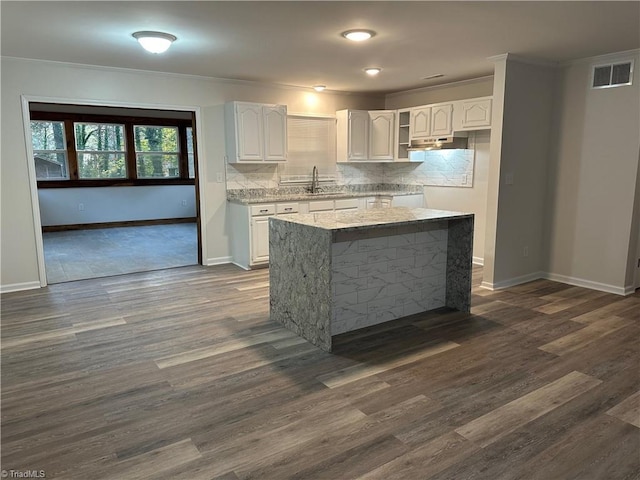 kitchen featuring white cabinets, decorative backsplash, crown molding, dark hardwood / wood-style flooring, and sink