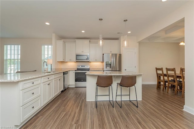 1837 Deveron Ct, Kernersville, NC 27284 - kitchen featuring appliances with stainless steel finishes, a peninsula, wood finished floors, white cabinets, and recessed lighting