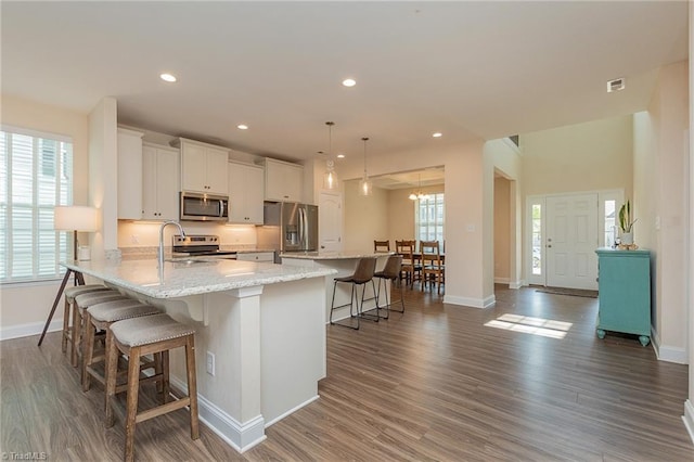 1837 Deveron Ct, Kernersville, NC 27284 - kitchen with stainless steel appliances, a kitchen breakfast bar, dark wood finished floors, white cabinetry, and recessed lighting
