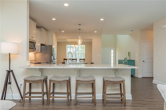 1837 Deveron Ct, Kernersville, NC 27284 - kitchen featuring appliances with stainless steel finishes, a peninsula, a breakfast bar area, white cabinetry, and recessed lighting